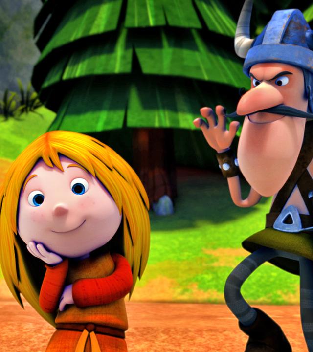 Ylvi sitzt in der Mitte des Bildes und schaut freundlich. Ein Pirat schleicht sich von hinten (rechts im Bild) an Ylvi an.