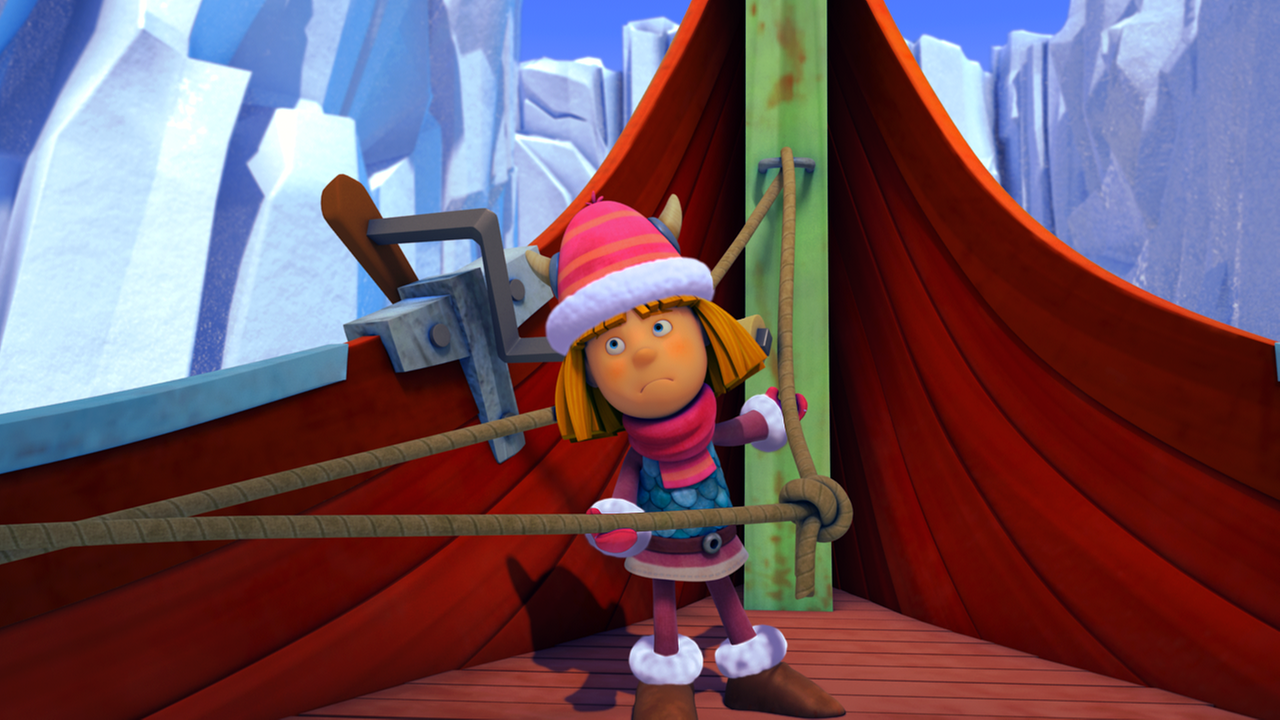 Wickie lenkt das Boot durch die Eisberge Dänemarks und hält dabei ein gespanntes Seil fest. Er ist warm angezogen.