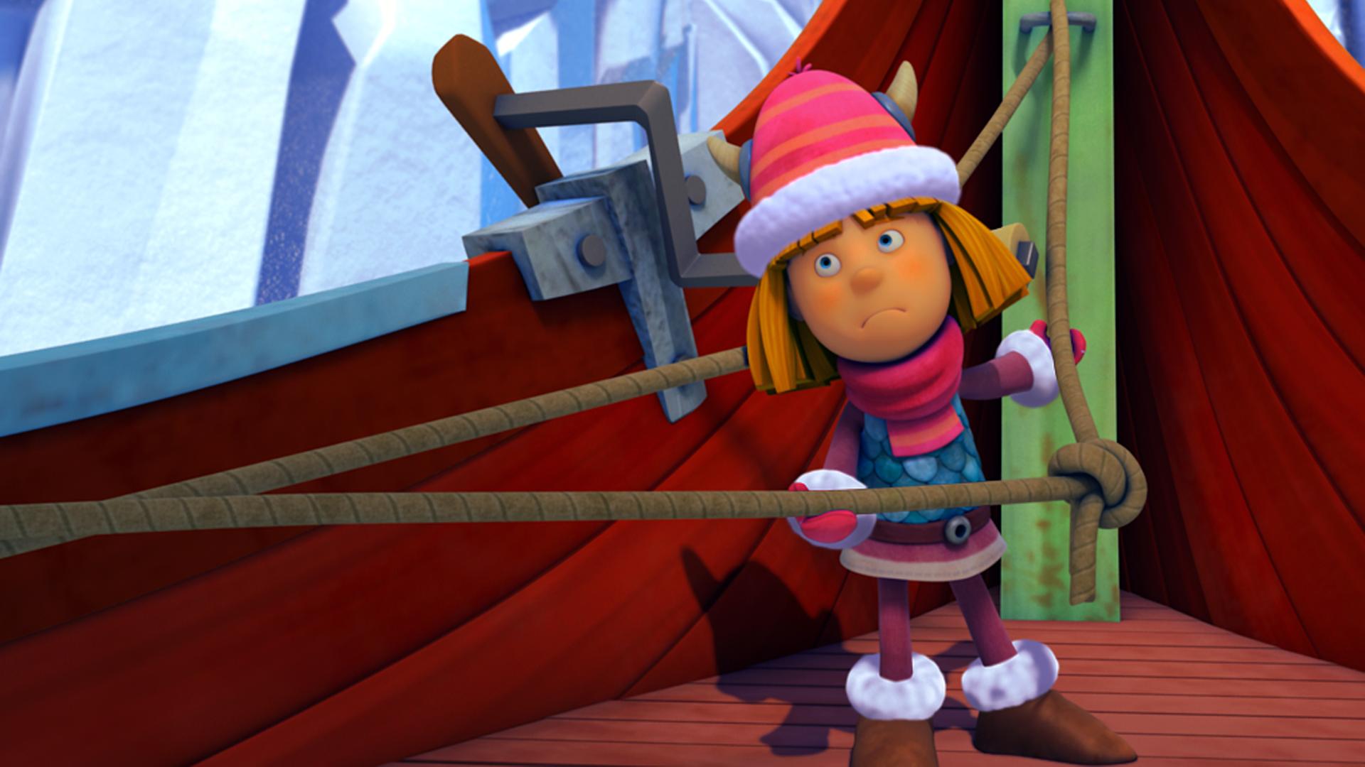 Wickie lenkt das Boot durch die Eisberge Dänemarks und hält dabei ein gespanntes Seil fest. Er ist warm angezogen.