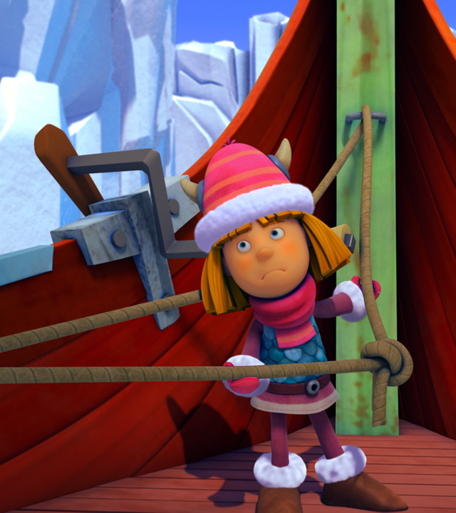 Wickie lenkt das Boot durch die Eisberge Dänemarks und hält dabei ein gespanntes Seil fest. Er ist warm angezogen.