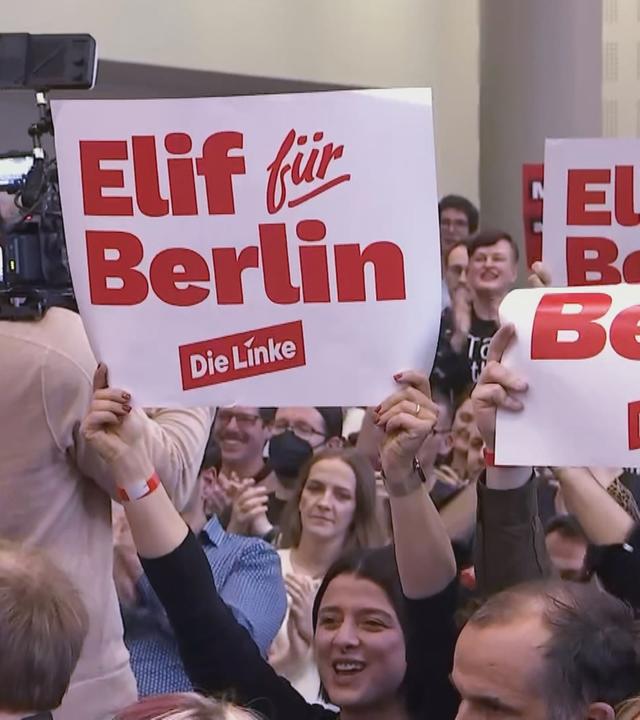 Bei einer Pressekonferenz von Elif Eralp halten Zuschauer Schuloder mit der Aufschrift "Elif für Berlin" hoch.