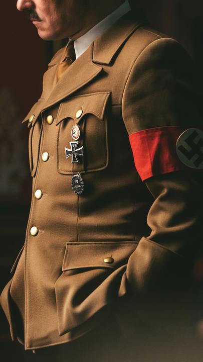 Nachgestellte Szene: Hitler (Schauspieler) vor einem Fenster in Uniform mit Hakenkreuz-Armbinde