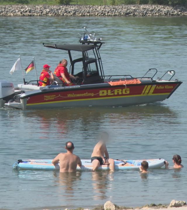Menschen baden zur Abkühlung im Fluss