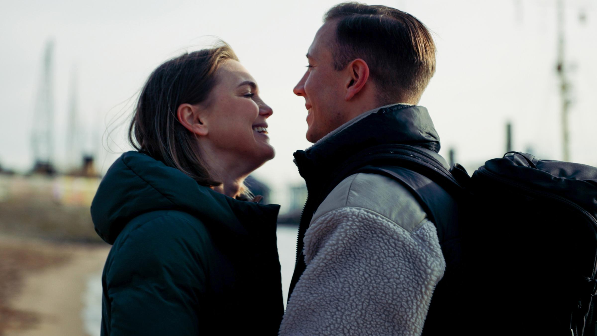 Svenja und Johannes stehen nah gegenüber und lächeln sich an.
