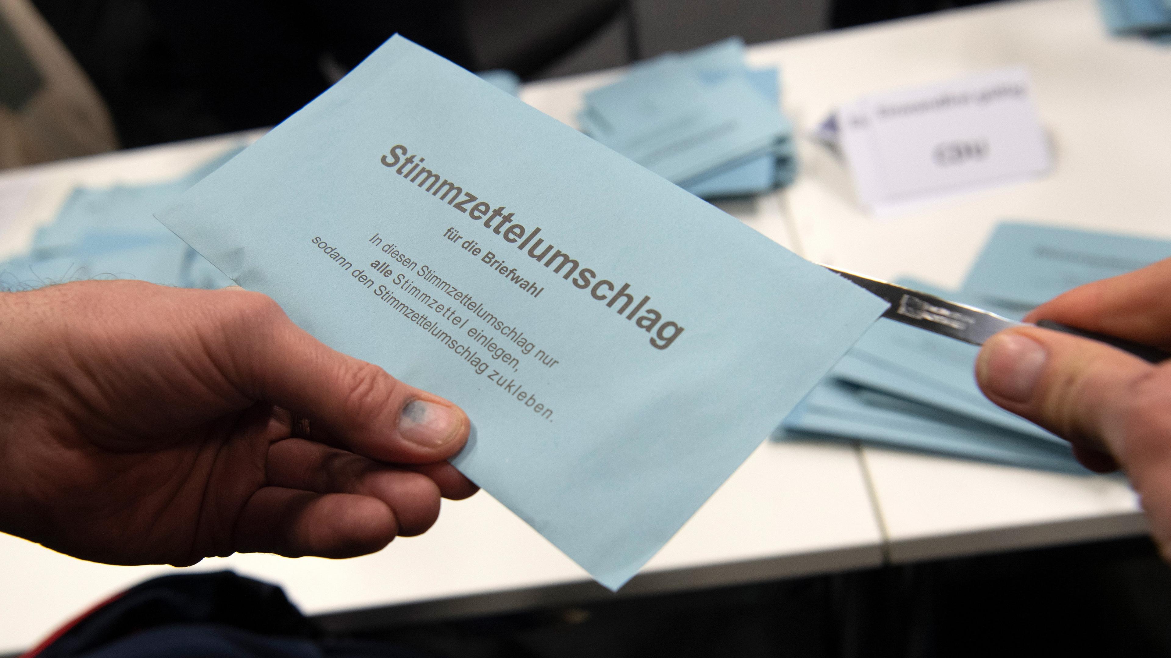 Berlin: Ein Wahlhelfer öffnet im City Cube nach der wiederholten Wahl den Stimmzettelumschlag eines Briefwählers.