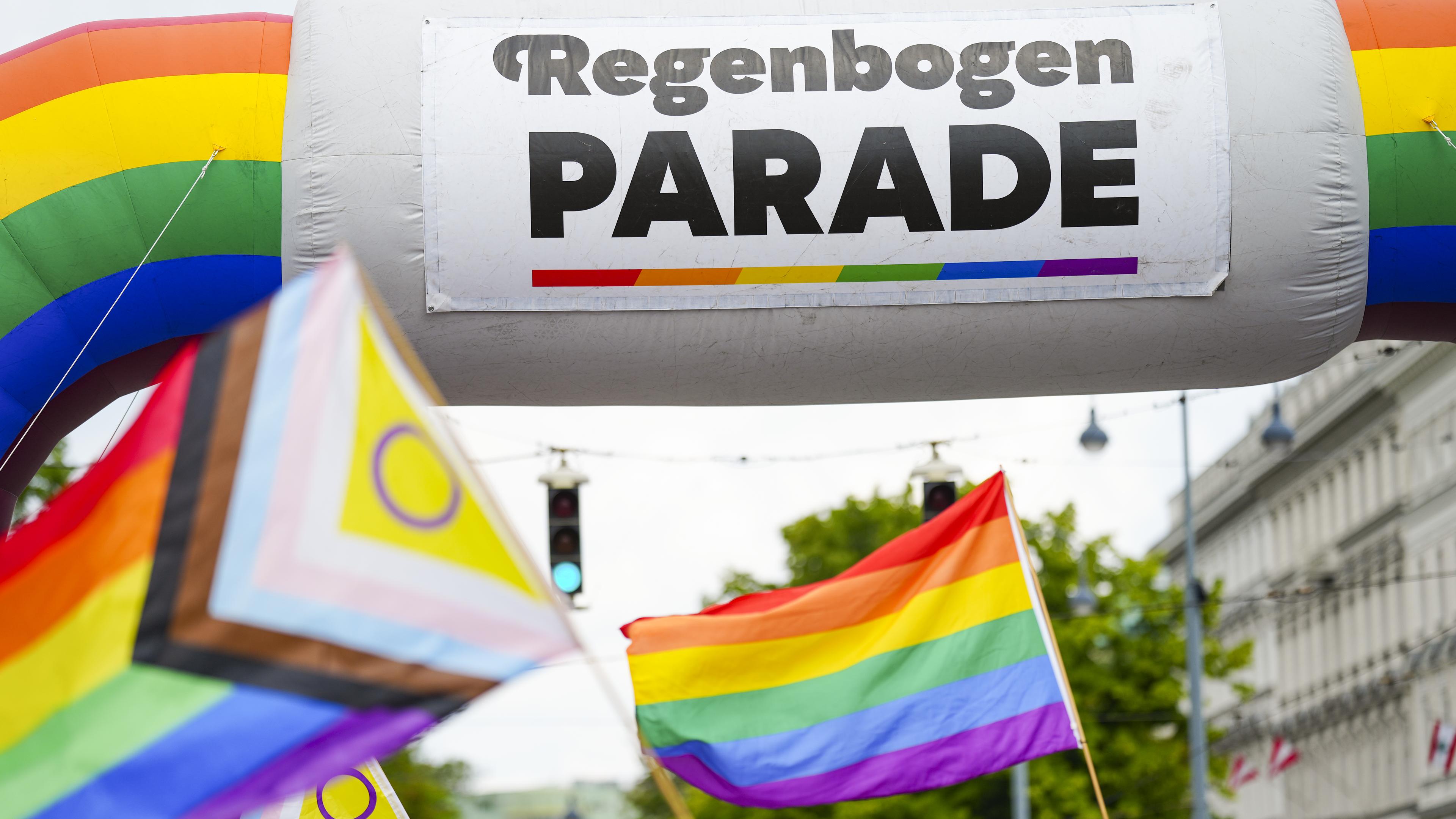 Regenbogen-Fahnen vor einem Banner mit der Aufschrift "Regebogen Parade" in Wien
