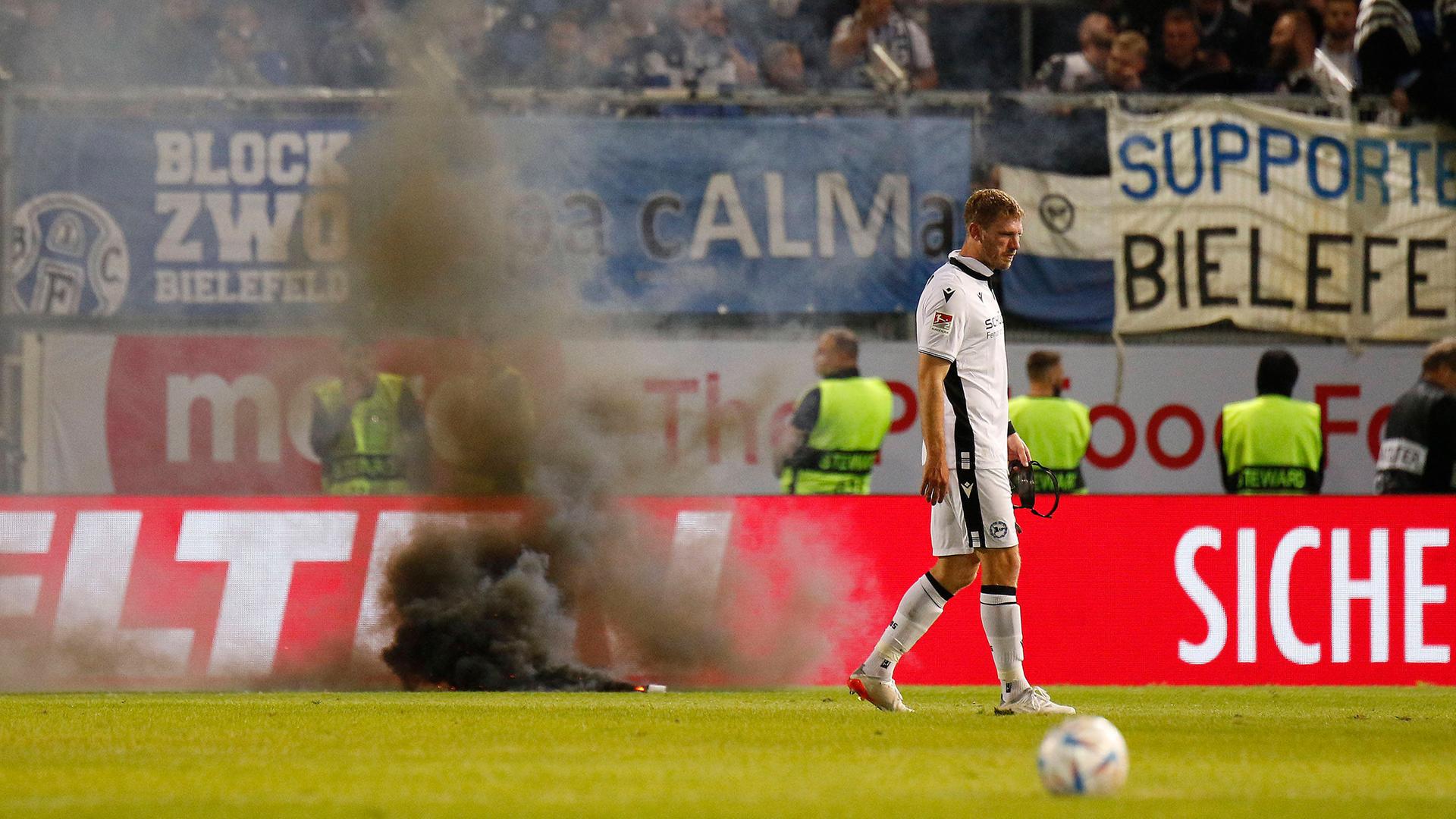 Pyrotechnik auf dem Spielfeld vor dem Fanblock von Arminia Bielefeld.