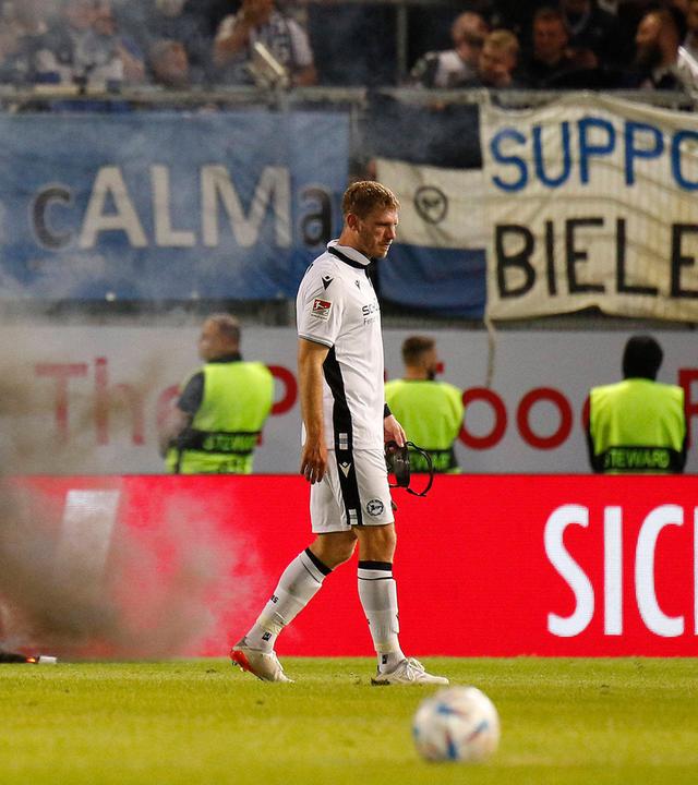 Pyrotechnik auf dem Spielfeld vor dem Fanblock von Arminia Bielefeld.