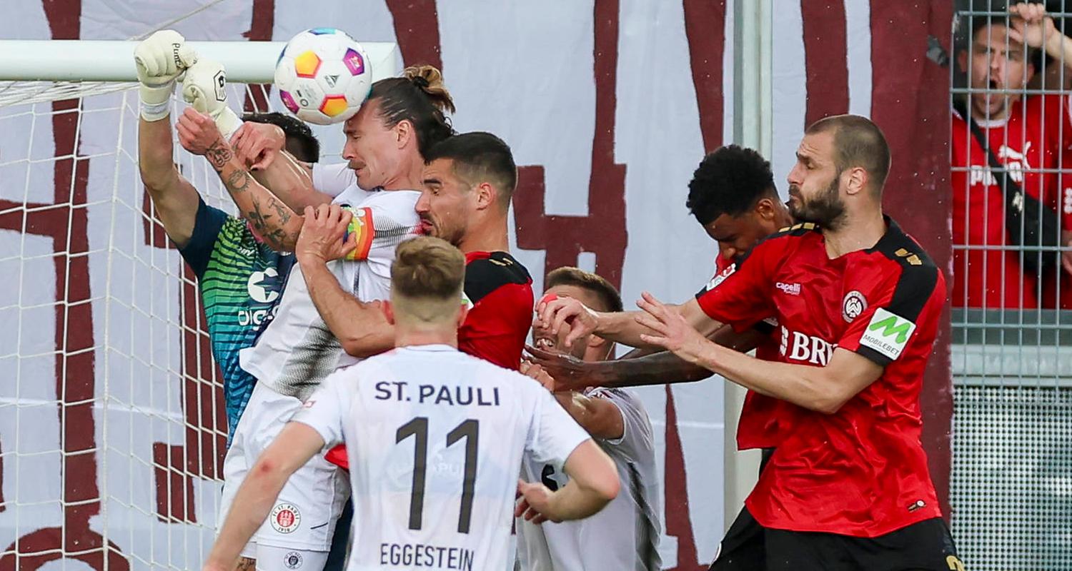 Torhueter Nikola Vasilj (St. Pauli), Jackson Irvine (St. Pauli), Johannes Eggestein (St. Pauli) und Sascha Mockenhaupt (Wiesbaden) kämpfen um den Ball am 19.05.24.
