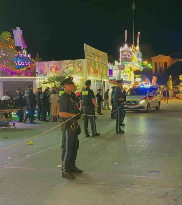 Zu sehen sind Polizisten die ein Fahrgeschäft absperren. 