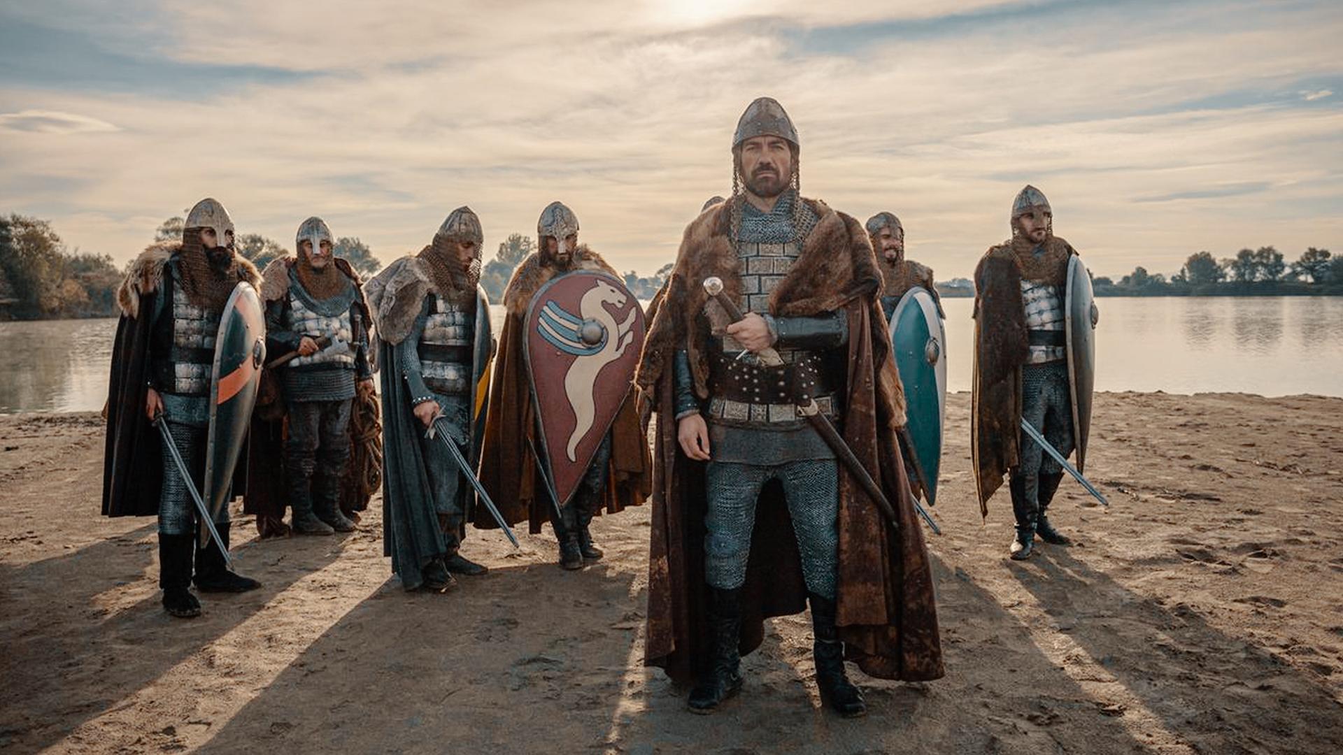 Nachgestellte Szene: Darsteller an einem Flussufer im Sand stehend, mit Schild und Schwert. Nachstellung als Wilhelm der Eroberer die Herrschaft über England an sich riss.