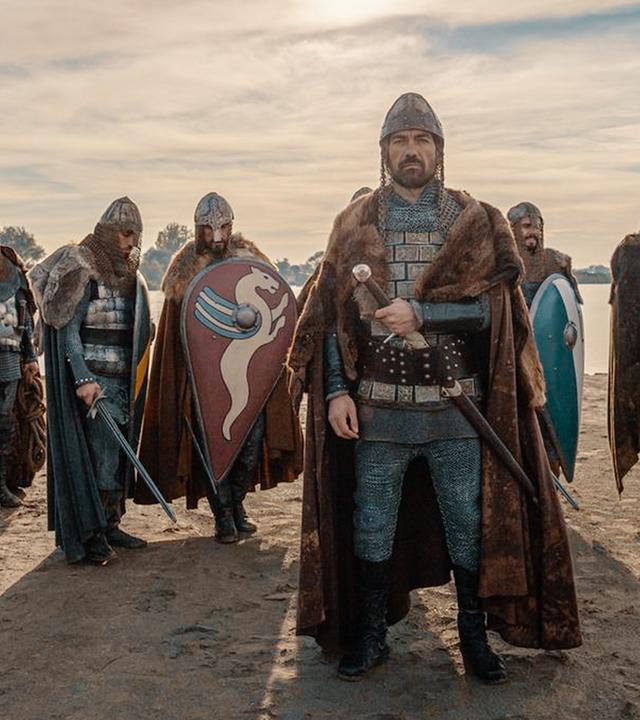 Nachgestellte Szene: Darsteller an einem Flussufer im Sand stehend, mit Schild und Schwert. Nachstellung als Wilhelm der Eroberer die Herrschaft über England an sich riss.