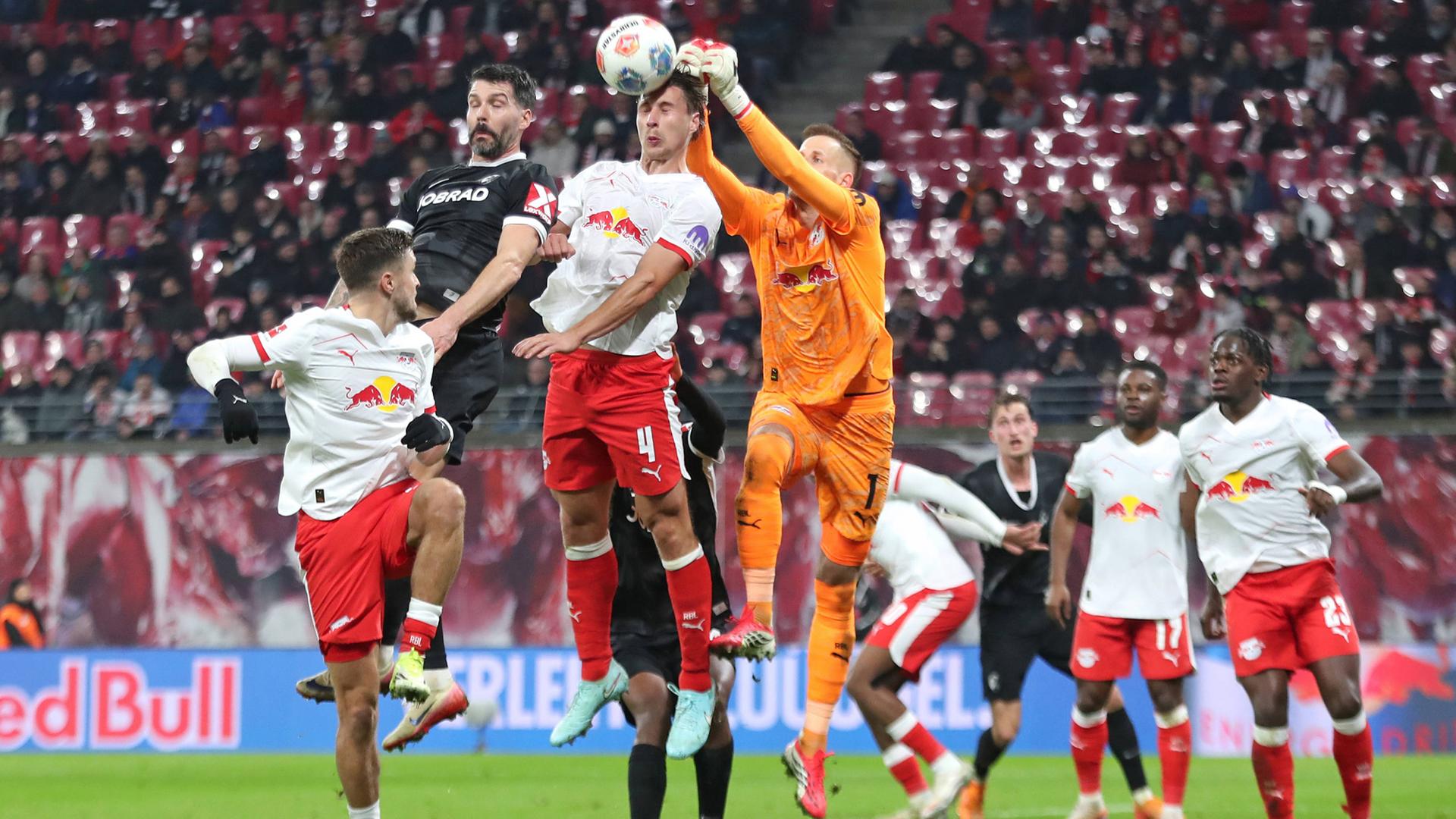Willi Orban (4) und Torwart Peter Gulácsi (1, RB Leipzig) verteidigen in der Luft gegen Anthony Jung (5, SC Freiburg).