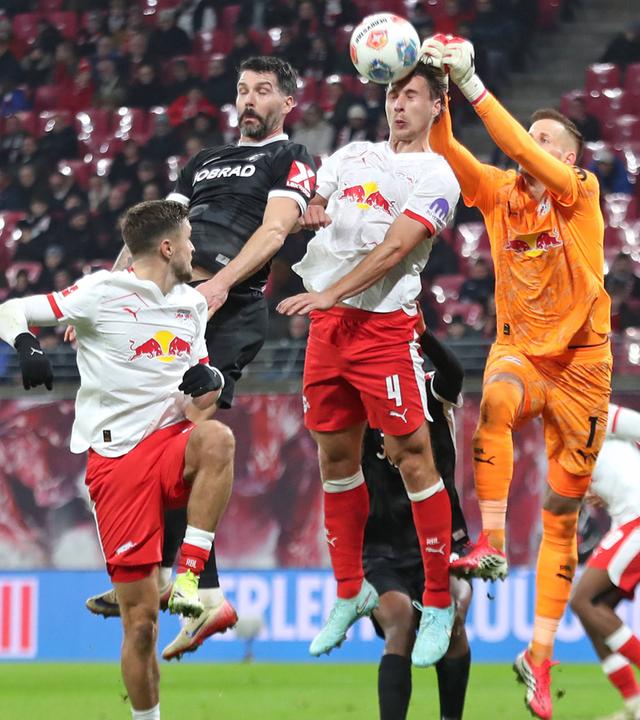 Willi Orban (4) und Torwart Peter Gulácsi (1, RB Leipzig) verteidigen in der Luft gegen Anthony Jung (5, SC Freiburg).