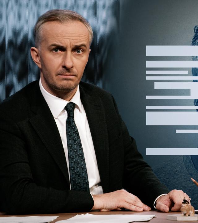 Jan Böhmermann sitzt am Schreibtisch. Rechts von ihm ist ein Porträt von Jeffrey Epstein zu sehen. Über seinem Gesicht verlaufen weiße Balken, die wie zensierte Passagen aus den Epstein-Akten aussehen.