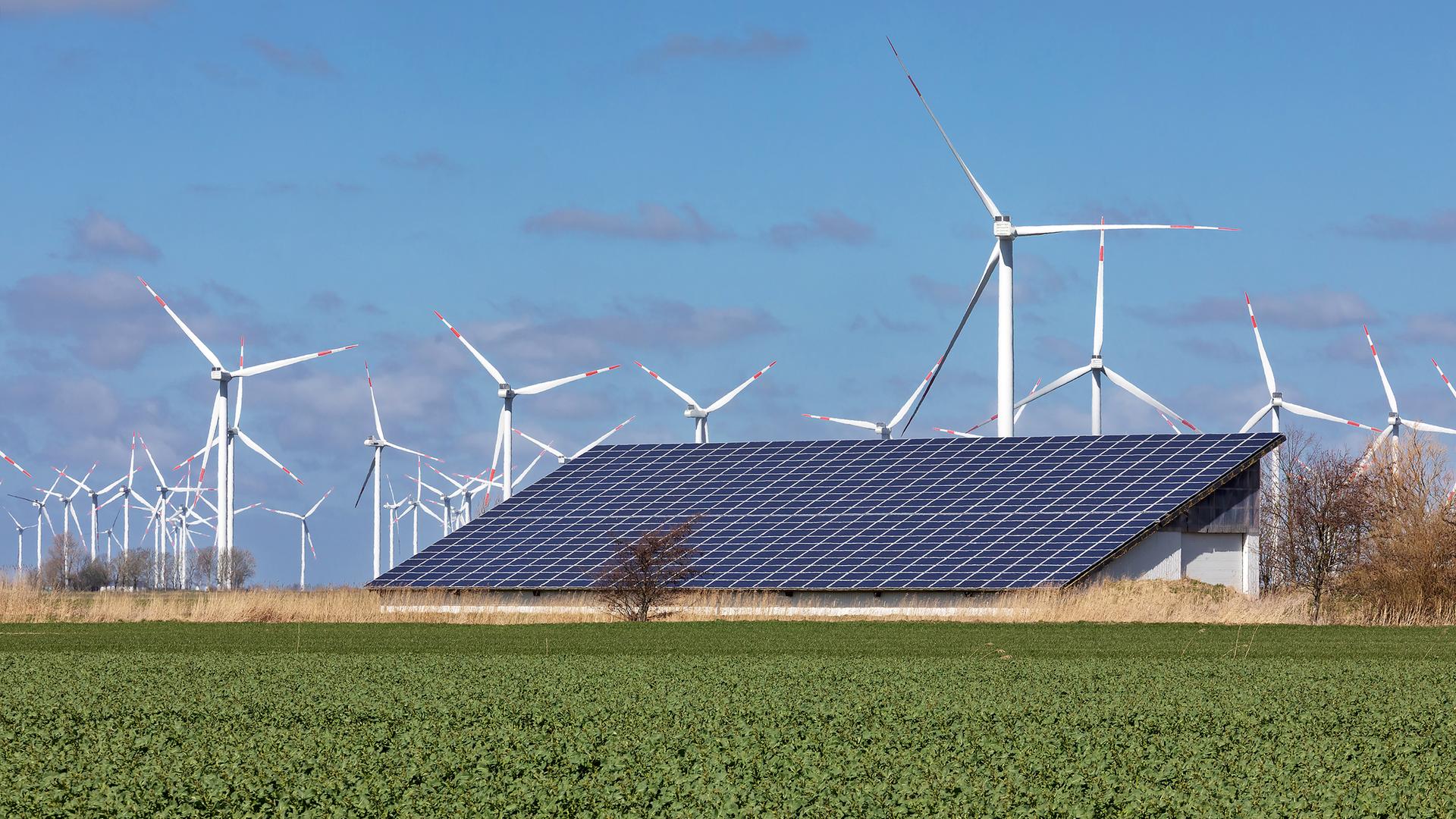 Landwirtschaftliches Gebäude mit Solardach und Windräder