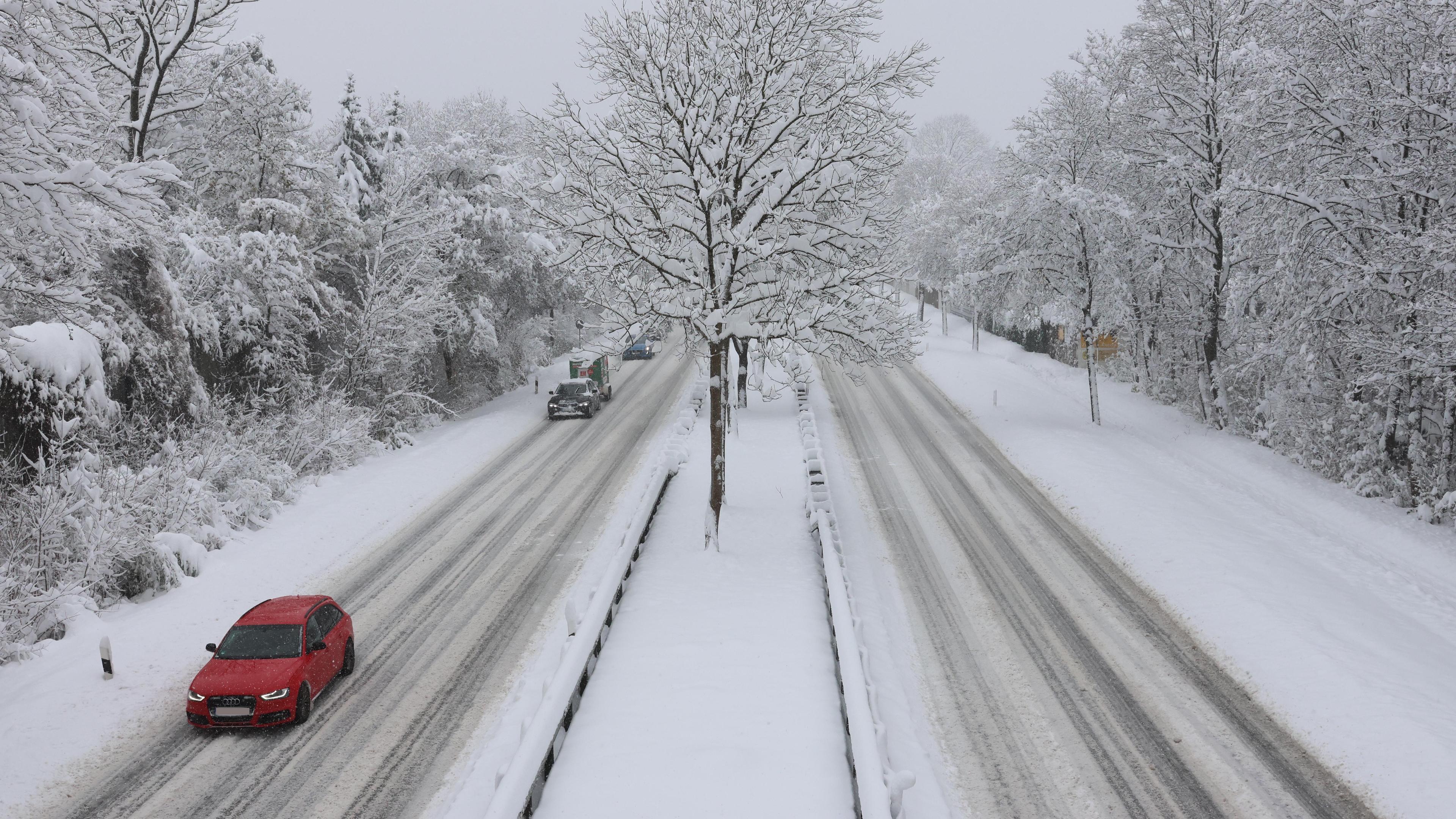 Autos fahren bei Schneefall auf der Bundesstrasse 304 bei Haar, München am 02.12.2023