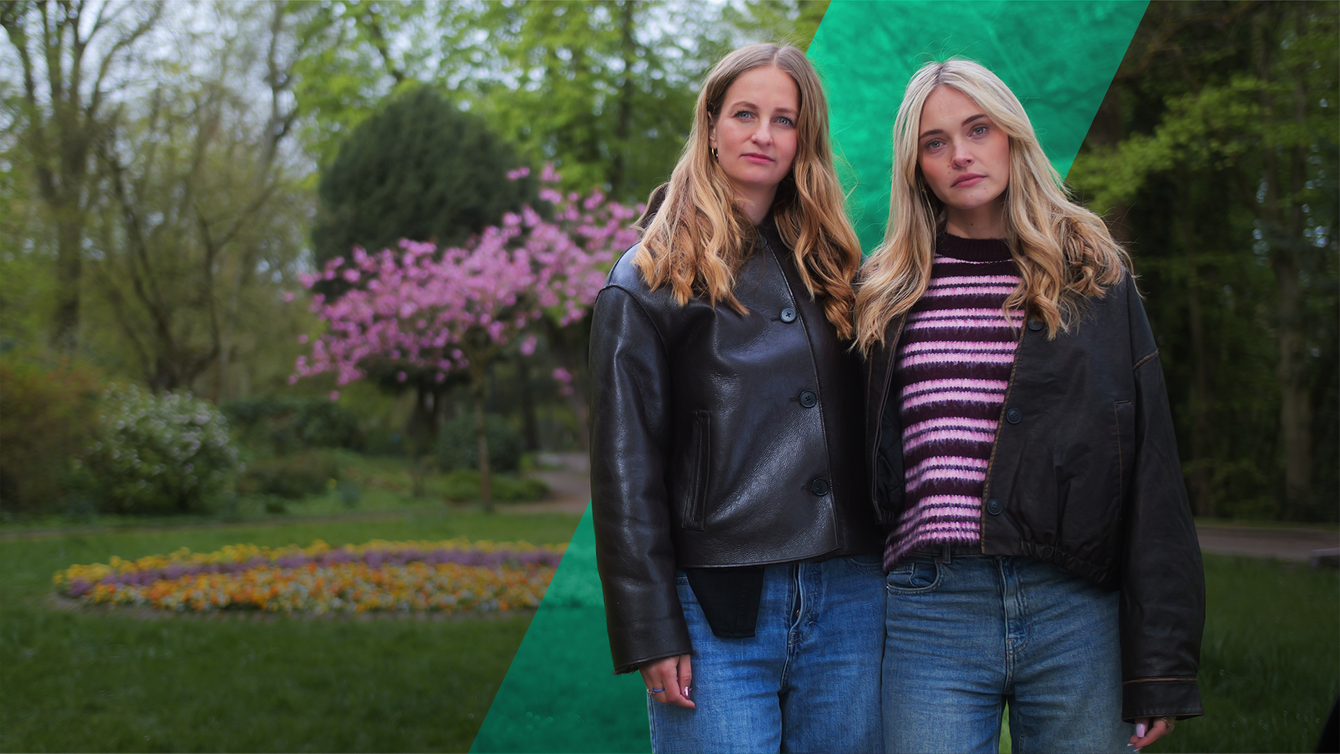 Malou und Jana stehen nebeneinander. Im Hintergrund ist eine Parkanlage zu sehen, mittig ein blühender Baum.