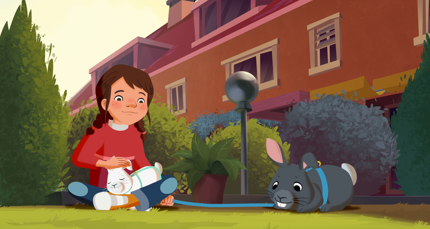 Tara sitzt im Schneidersitz auf der Wiese und streichelt ein weißes Kaninchen, das graue hält sie an der Leine.