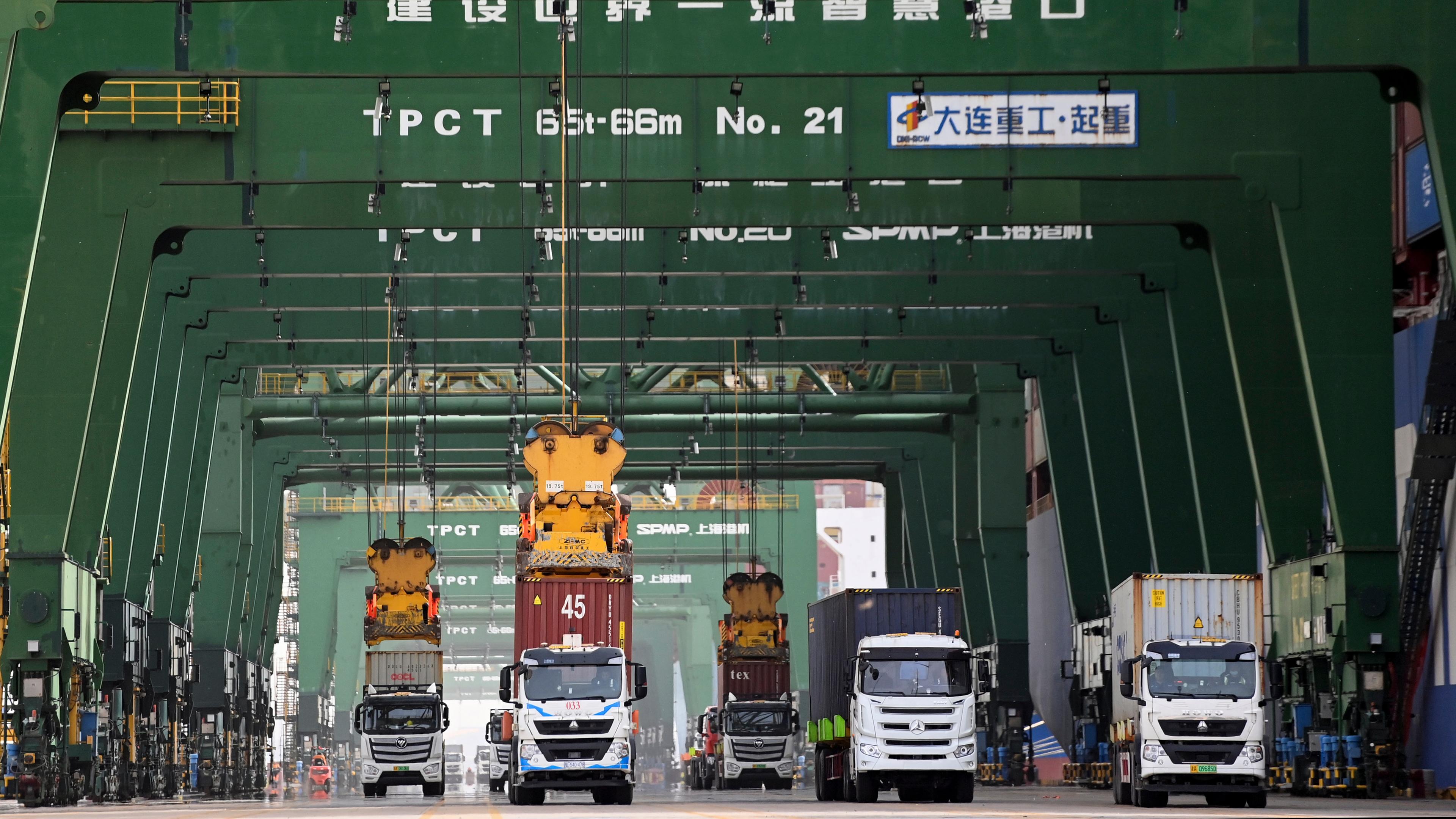 Container werden im Pacific International Terminal des Tianjin-Hafens in der nordchinesischen Stadt Tianjin auf Lastwagen transportiert