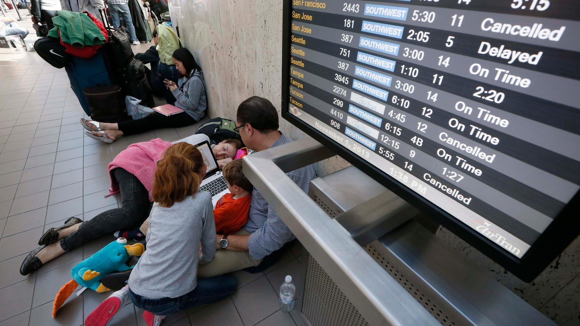 Menschen warten am Flughafen auf den Flieger.