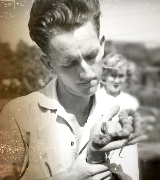 Auf der einen Seite ist ein Totenkopf als Giftsymbol unter mathematischen Formeln auf dunklem Hintergrund abgebildet. Auf der anderen Seite liegt das Schwarz-Weiß-Foto von Kevin Budden, der eine Schlange in den Händen hält. Hinter ihm steht eine Frau und beobachtet ihn.