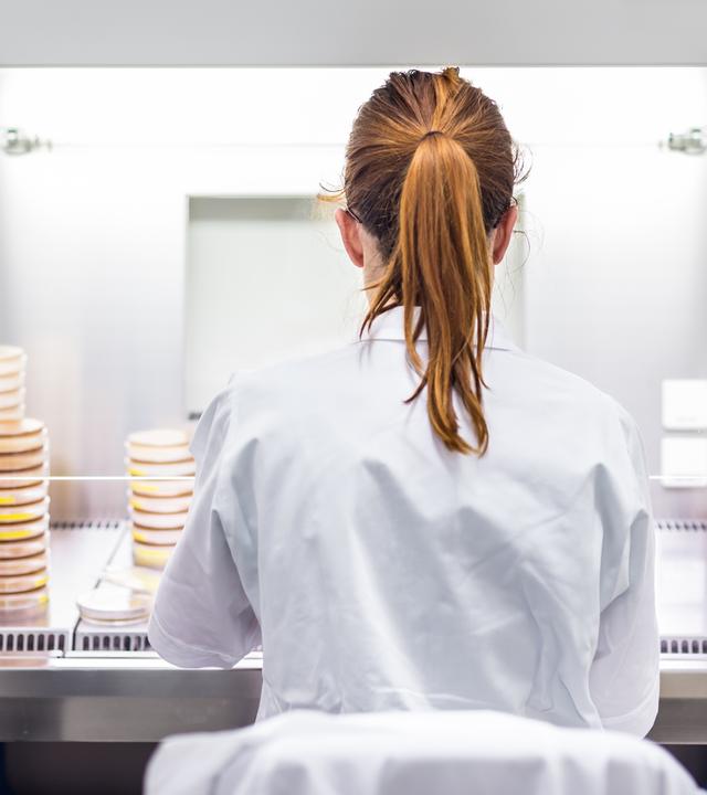 Wissenschaftlerin - von hinten zu sehen - bei Arbeiten im Labor.