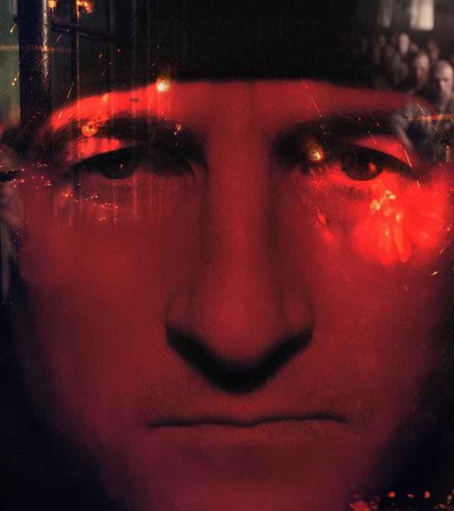 Putins Krieger - Ein russischer Elite-Kämpfer packt aus": Montage: Das Gesicht von Witalij ist in Rot getaucht und durchscheinend verschwommen vor schwarzen Hintergrund.