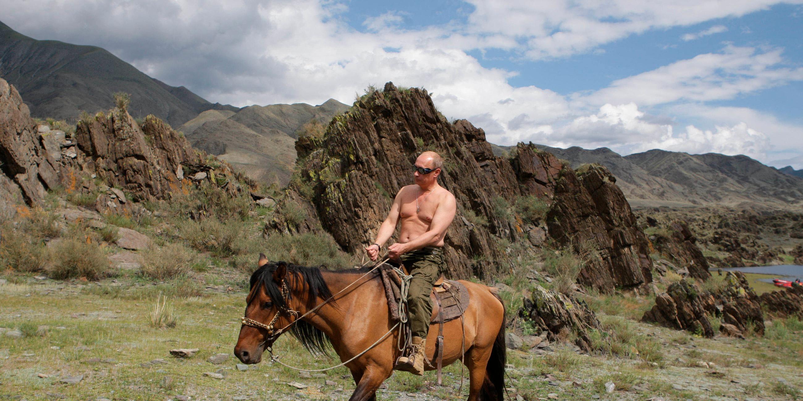 Der russische Präsident Wladimir Putin reitet mit freiem Oberkörper durch die Berge Sibiriens.