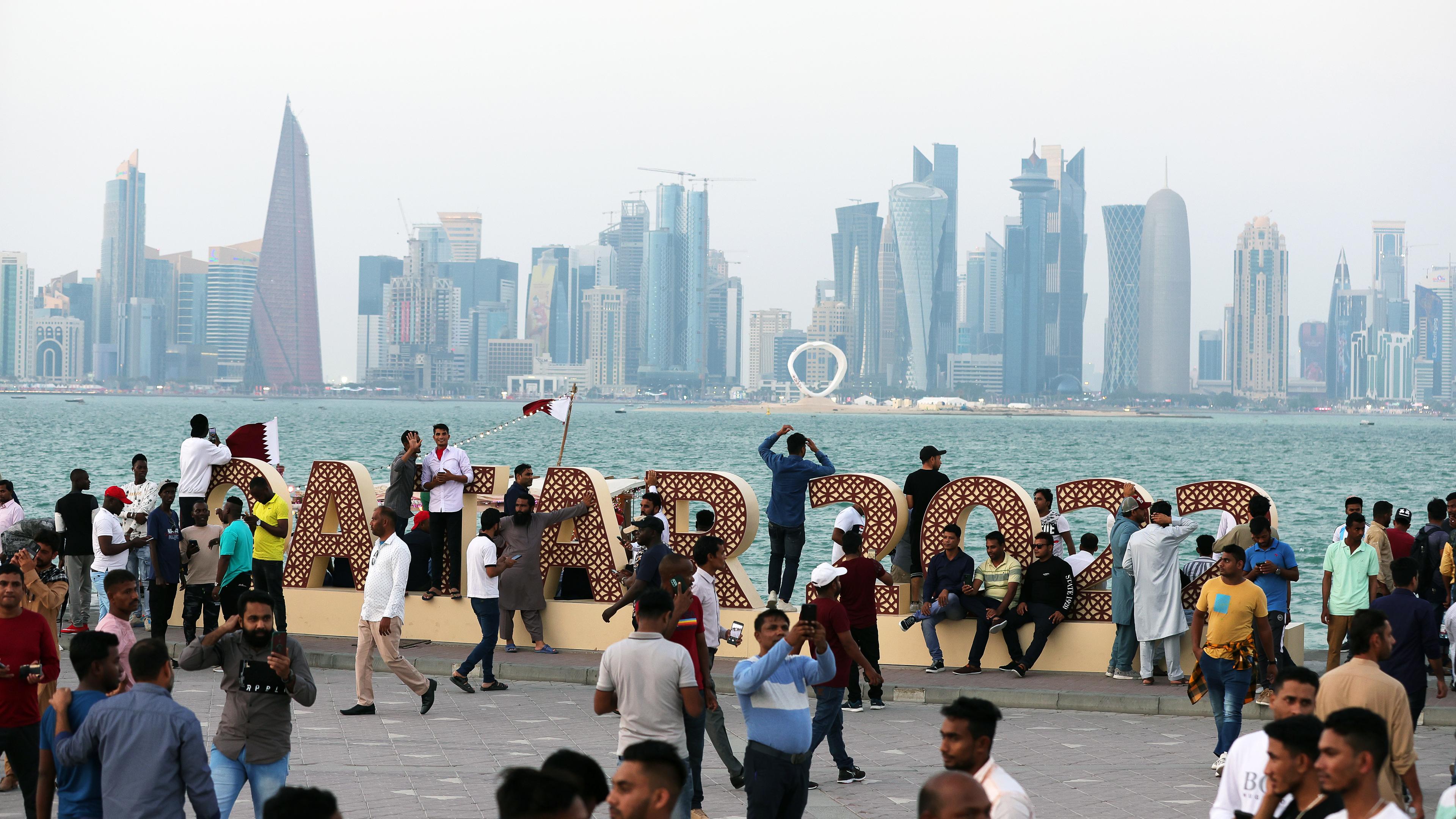 FIFA World Cup 2022 - Menschen vor dem Schriftzug in Katar