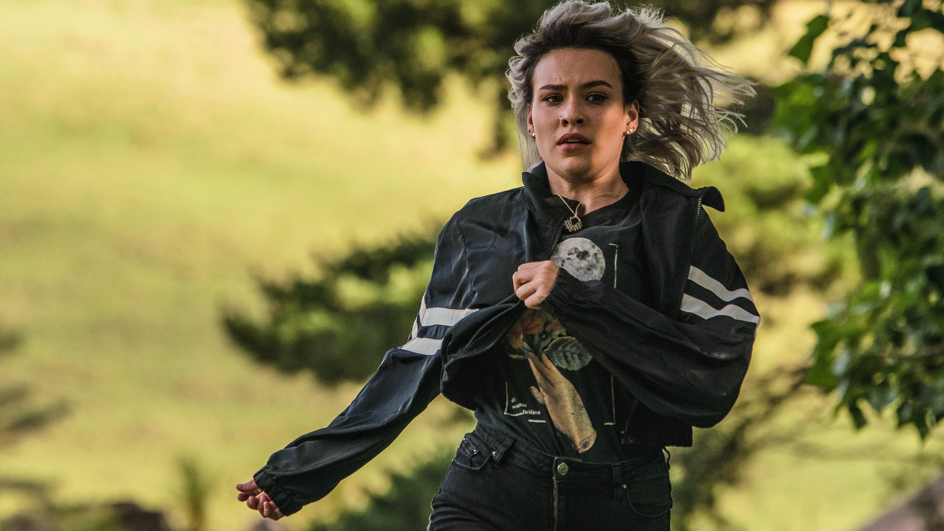 Issie rennt über eine Wiese.