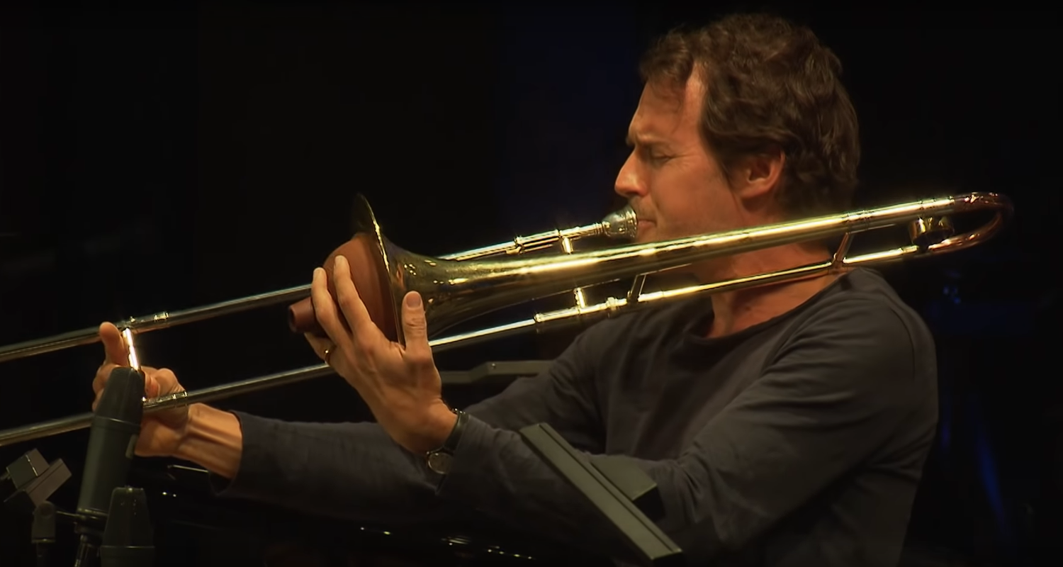 Posaunist Nils Wogram seitlich, beim Spielen aufgenommen.