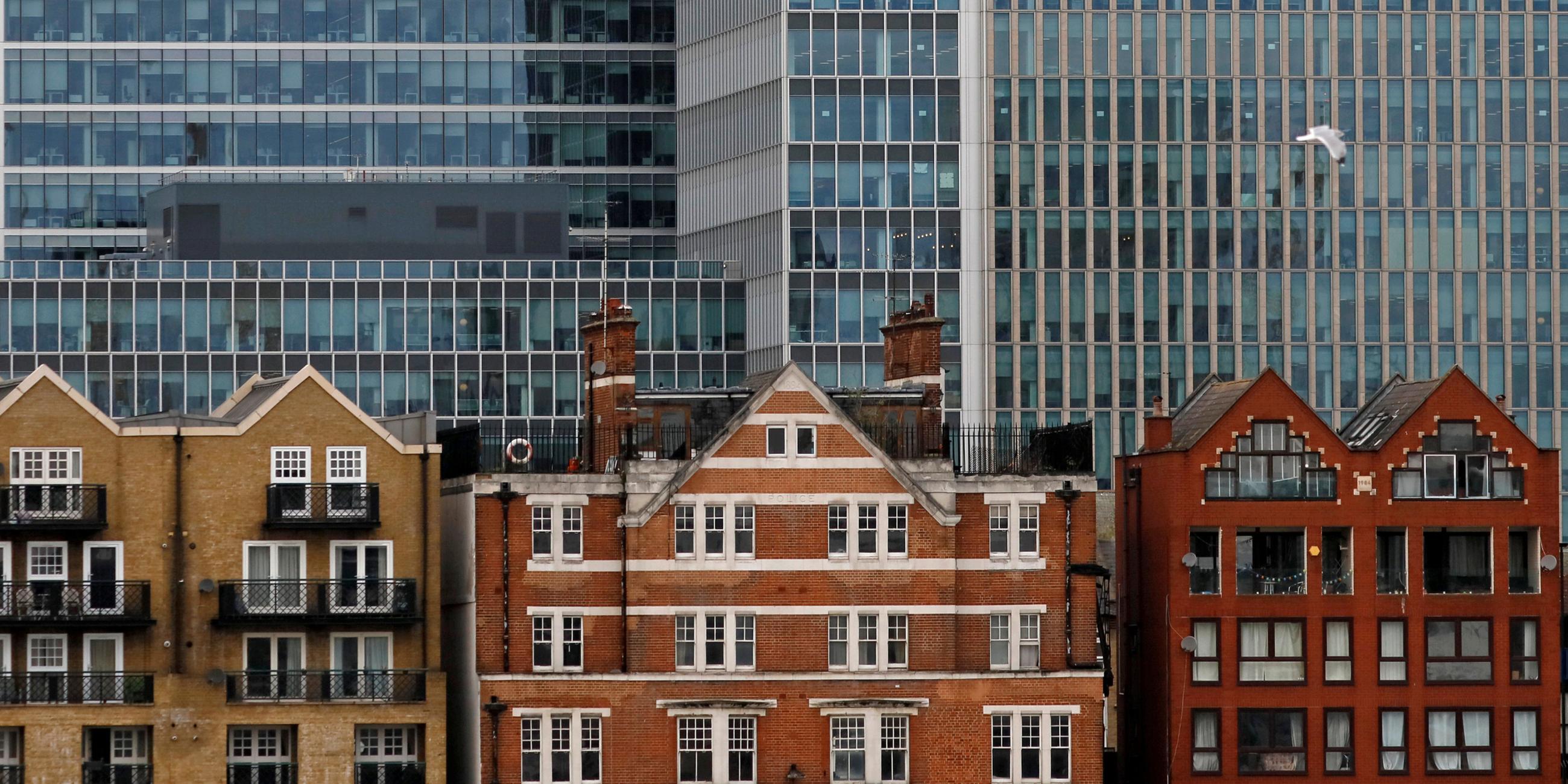 Vor dem Hintergrund von Bankhochhäusern in Canary Wharf in London, Großbritannien, 30. Oktober 2015, stehen Wohnhäuser.