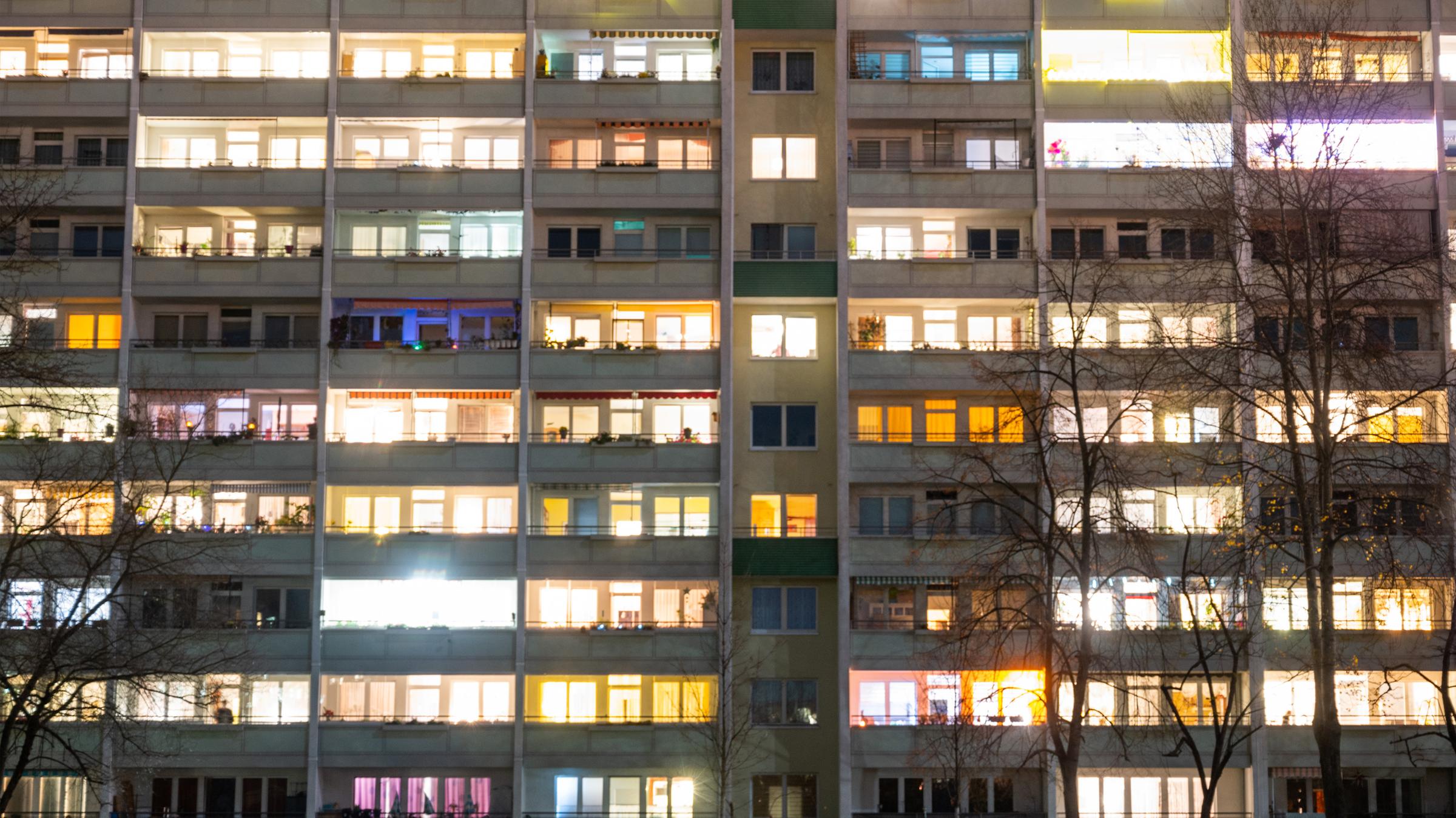 In einem Hochhaus sind einige Fenster beleuchtet. 