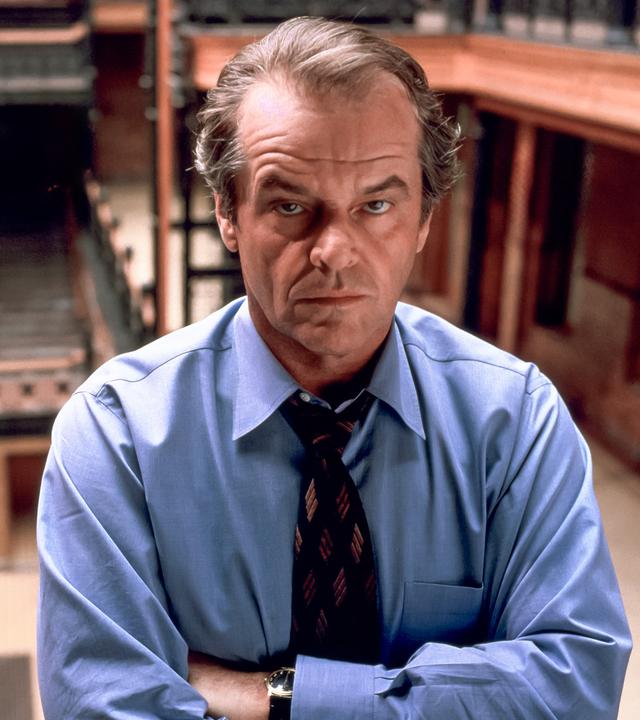 Großaufnahme von Will Randall (Jack Nicholson) der mit verschränkten Armen in einer Art Bibliothek steht und ernst nach vorne blickt.