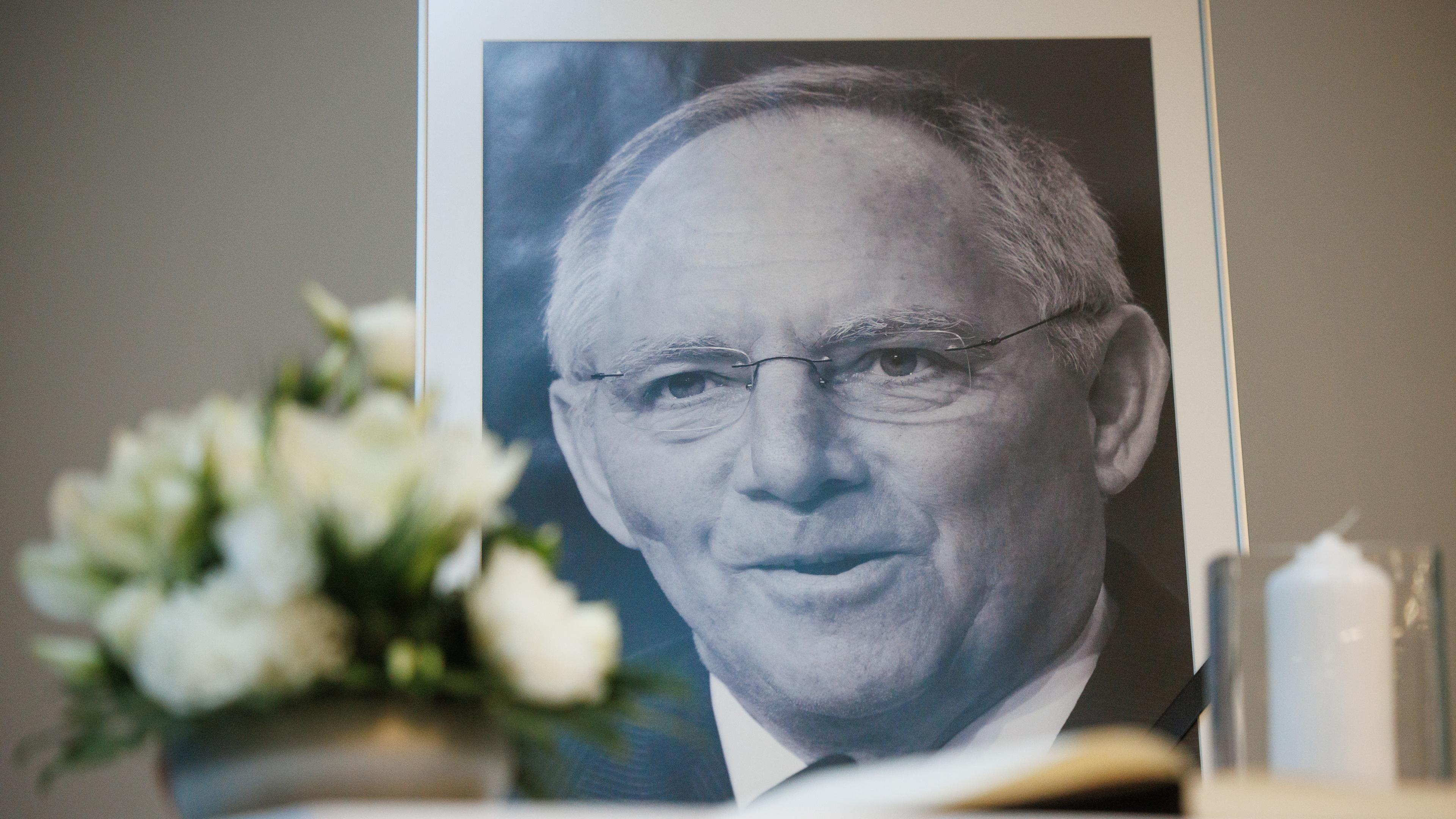 A condolence book and a portrait photo showing former German Parliament Bundestag president Wolfgang Schaeuble, next to a bouquet of flowers and a candle, are set up at the Konrad Adenauer Haus, the headquarters of the Christian Democratic Union (CDU) party, on the occasion of the announcement of Schaeuble's death in Berlin, Germany, 27 December 2023.
