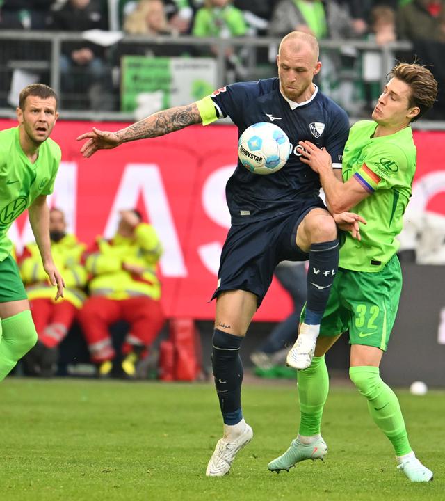 Bochums Philipp Hofmann (M) spielt gegen Wolfsburgs Mattias Svanberg (r) und Wolfsburgs Denis Vavro. 