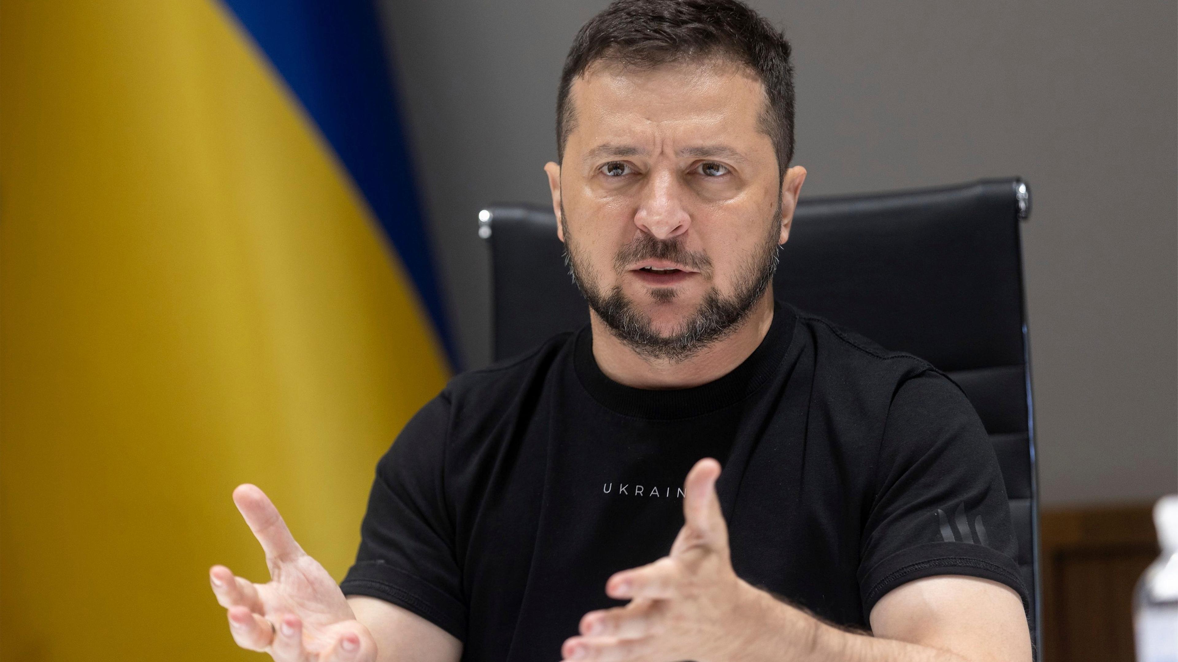 Wolodymyr Selenskyj spricht vor einer ukrainischen Flagge