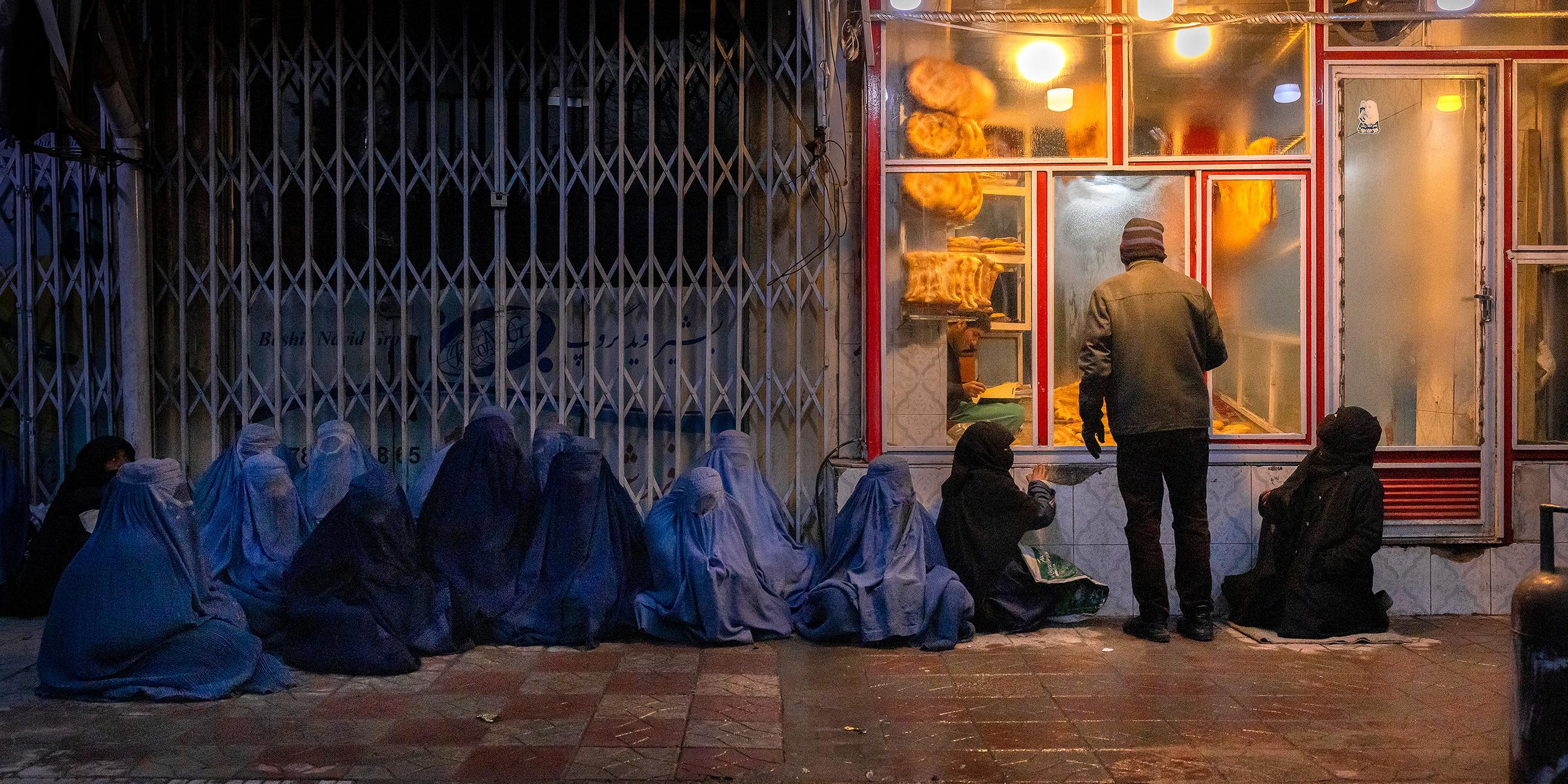 Frau und Kinder betteln vor einer Bäckerei im Zentrum Kabuls um Essen.