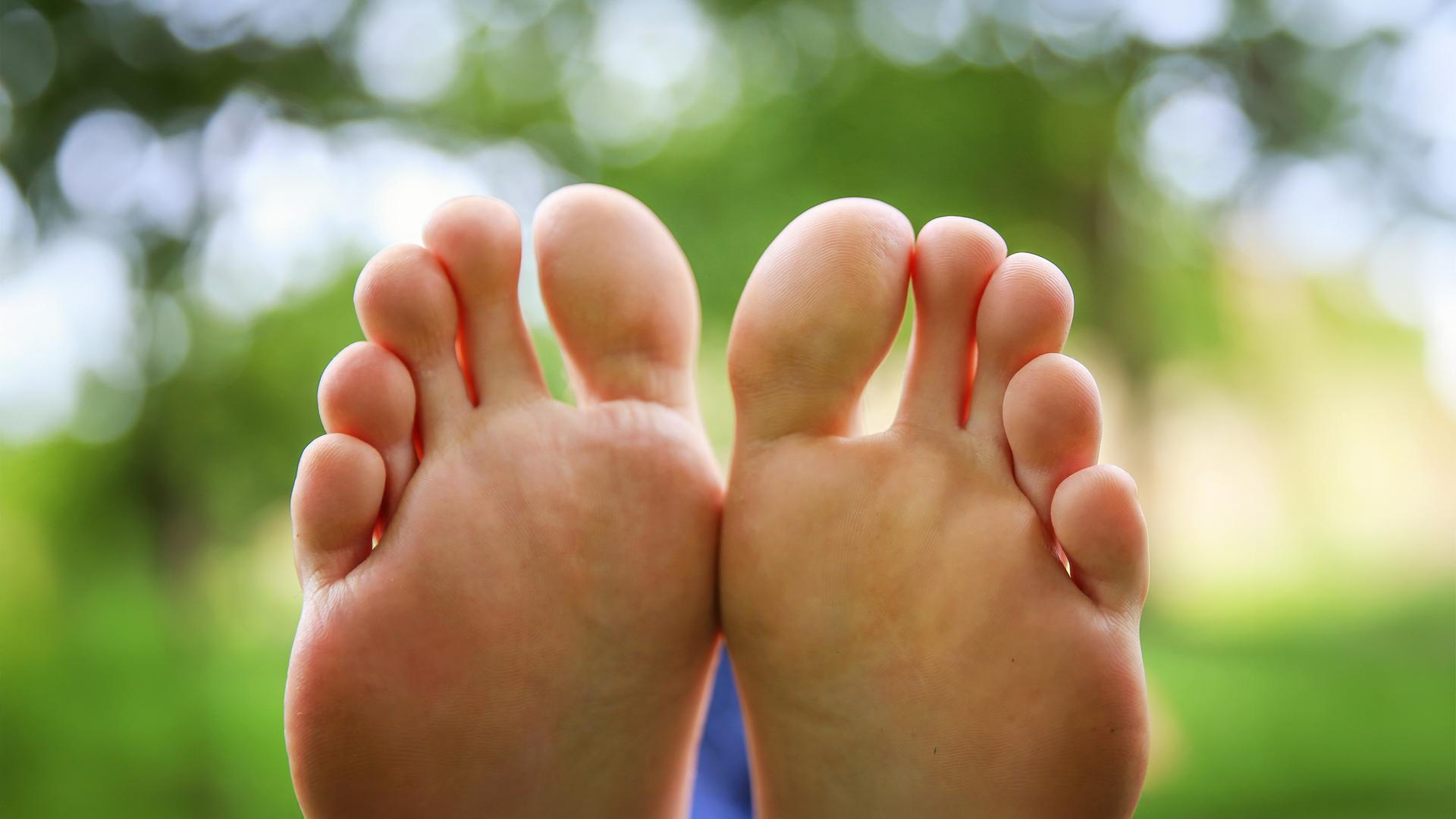 Die Welt von unten betrachtet – zwei Füße, die in ihrer natürlichen Form Geschichten erzählen.