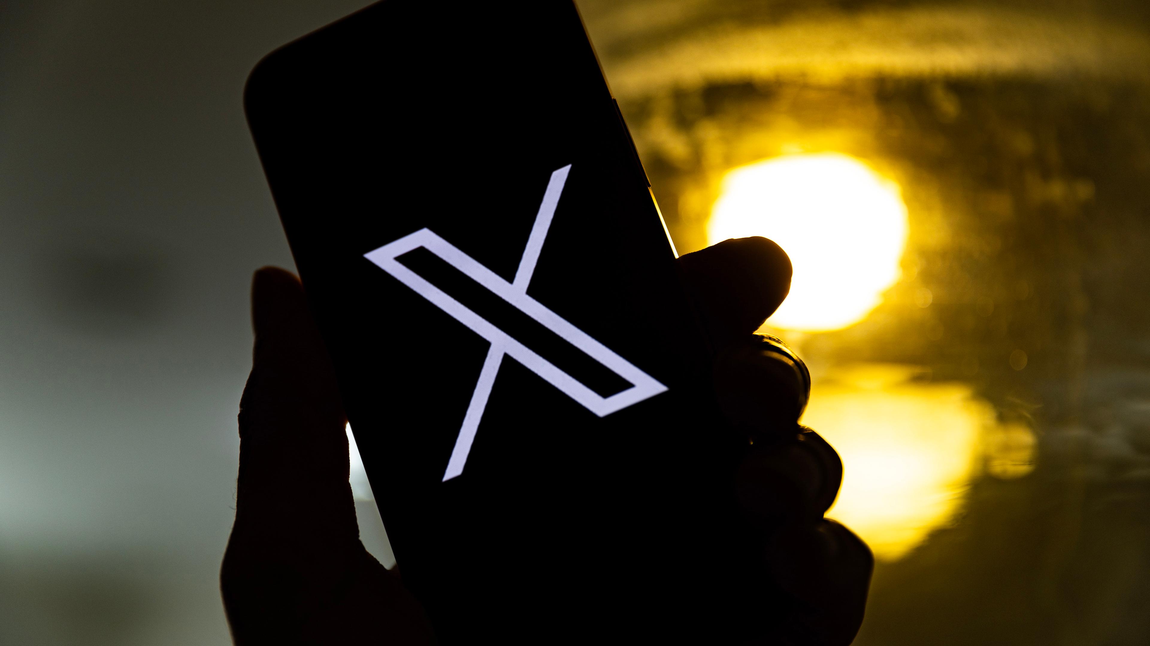 Eine Illustration zeigt einen Nutzer, der ein Mobiltelefon mit dem "X"-Logo in der Hand hält, in Los Angeles, Kalifornien, USA, am 27.07.2023. 