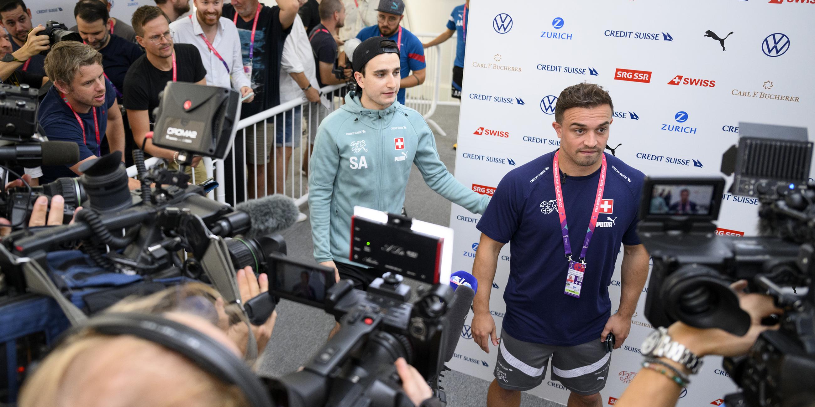 Der Schweizer Mittelfeldspieler Xherdan Shaqiri (r) spricht mit Journalisten neben dem Pressesprecher des Schweizerischen Fußballverbandes, Sergio Avuso