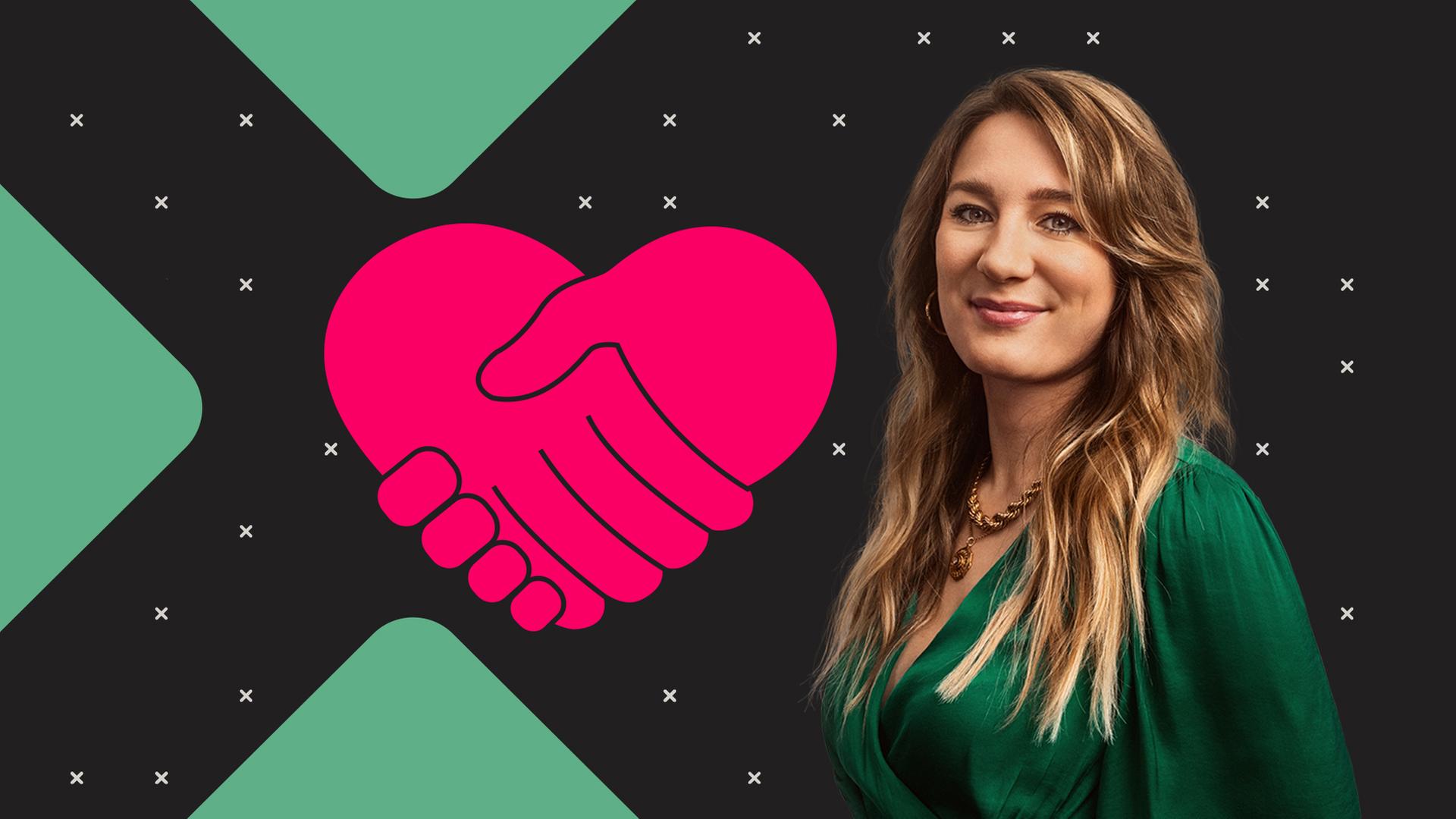 Hilfsbereitschaft: Biologin Jasmina Neudecker steht vor einer Grafik, die zwei einander haltende Hände zeigt, die zu einem Herz geformt sind.