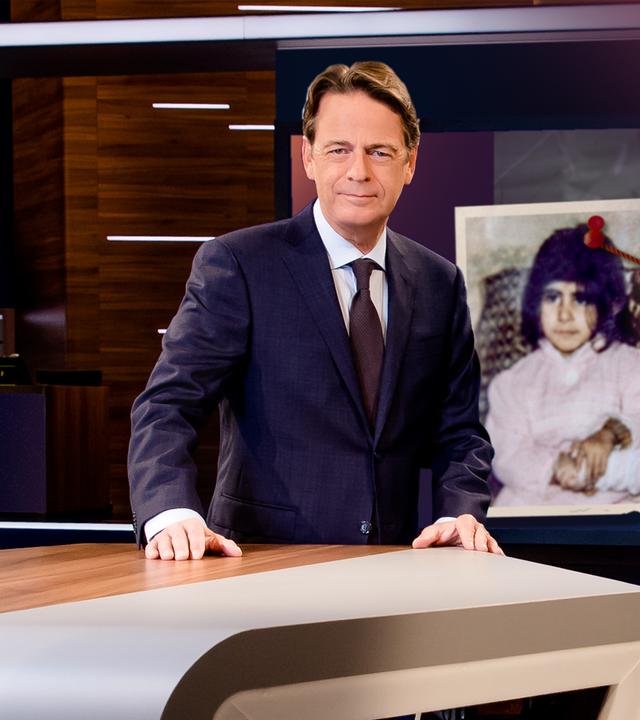 "Aktenzeichen XY... Ungelöst vom 26. November 2025": Rudi Cerne steht im Studio, im Hintergrund ein Bildschirm, auf dem ein Fall der Sendung abgebildet ist.