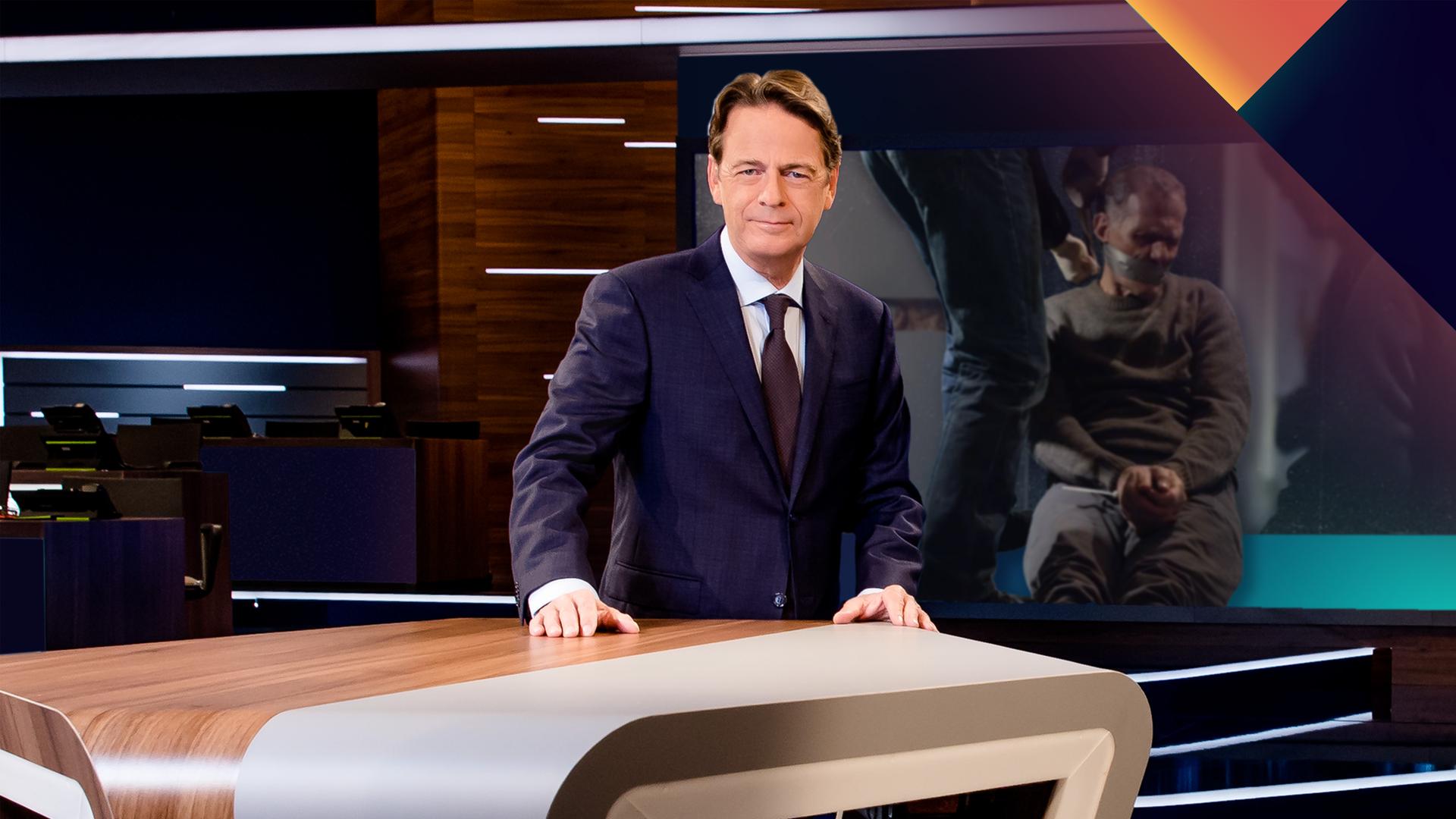 "Aktenzeichen XY... Ungelöst vom 08. April 2026": Rudi Cerne steht im Studio, im Hintergrund ein Bildschirm, auf dem ein Fall der Sendung abgebildet ist.