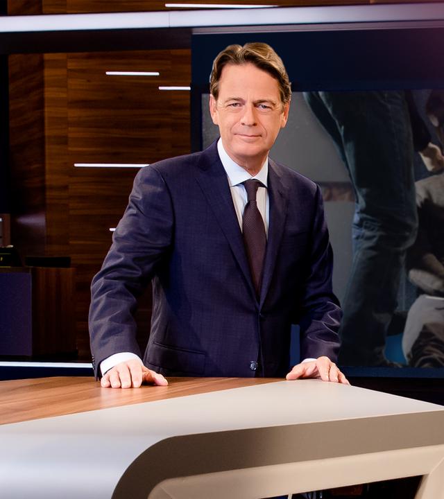 "Aktenzeichen XY... Ungelöst vom 08. April 2026": Rudi Cerne steht im Studio, im Hintergrund ein Bildschirm, auf dem ein Fall der Sendung abgebildet ist.