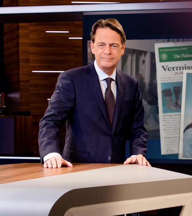 "Aktenzeichen XY... Ungelöst vom 19. August 2026": Rudi Cerne steht im Studio, im Hintergrund ein Bildschirm, auf dem ein Fall der Sendung abgebildet ist.