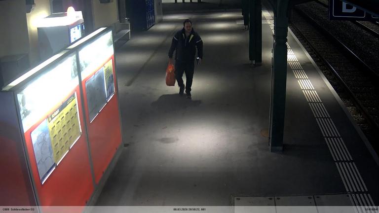 "Videoaufnahme zum Vermisstenfall Andreas Portmann aus der XY-Sendung vom 09.09.2026": Der Vermisste Andreas Portmann geht einen Bahnsteig entlang, wobei man die auffällige Bewegung seines Kopfes erkennen kann. 