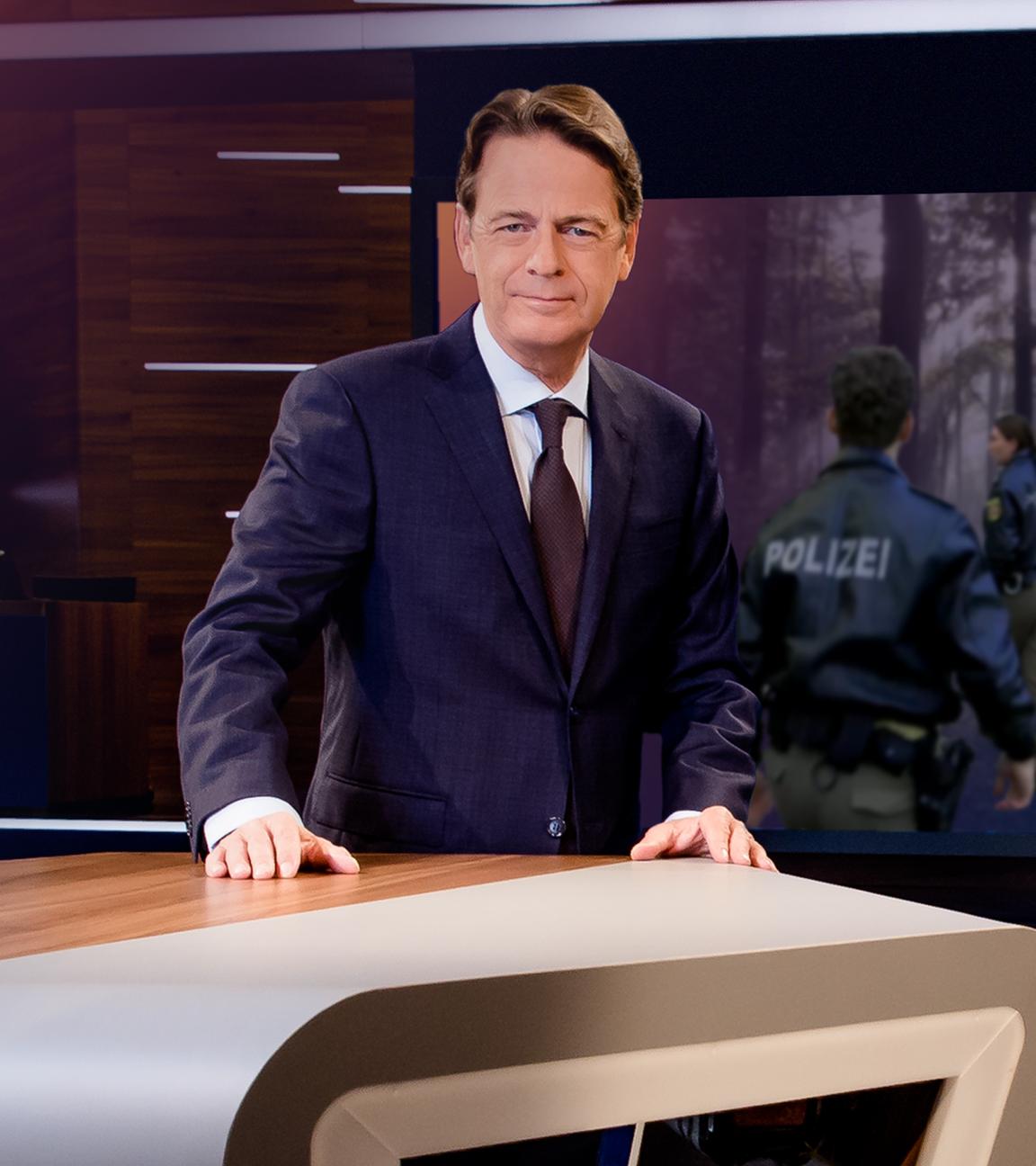 "Aktenzeichen XY... Gelöst vom 06. März 2024": Moderator Rudi Cerne steht im Studio, im Hintergrund ein Bildschirm, auf dem ein Fall der Sendung abgebildet ist.  
