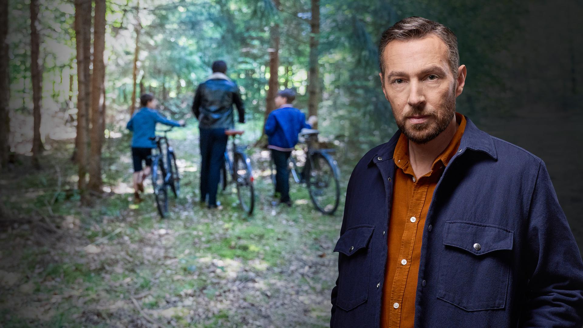 Sven Voss vor einem Foto von 2 Kindern und einem jungen Mann im Wald mit Fahrrädern.